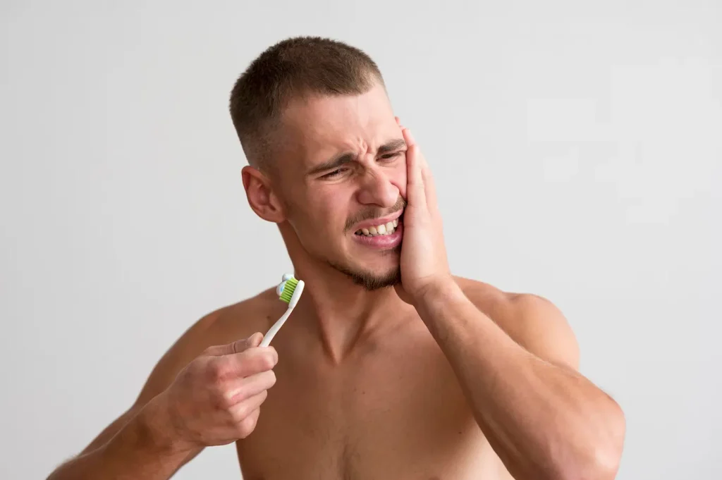 persona con dolor de encía y un cepillo dental